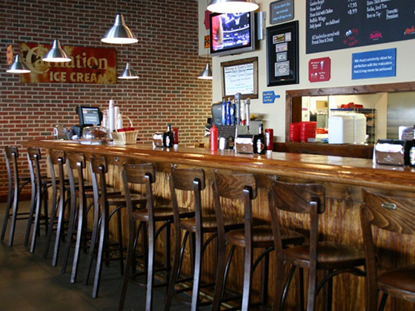 inside of a bar with wooden chairs